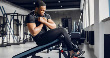 Man exercising core muscles on an incline bench in a modern gym with natural light